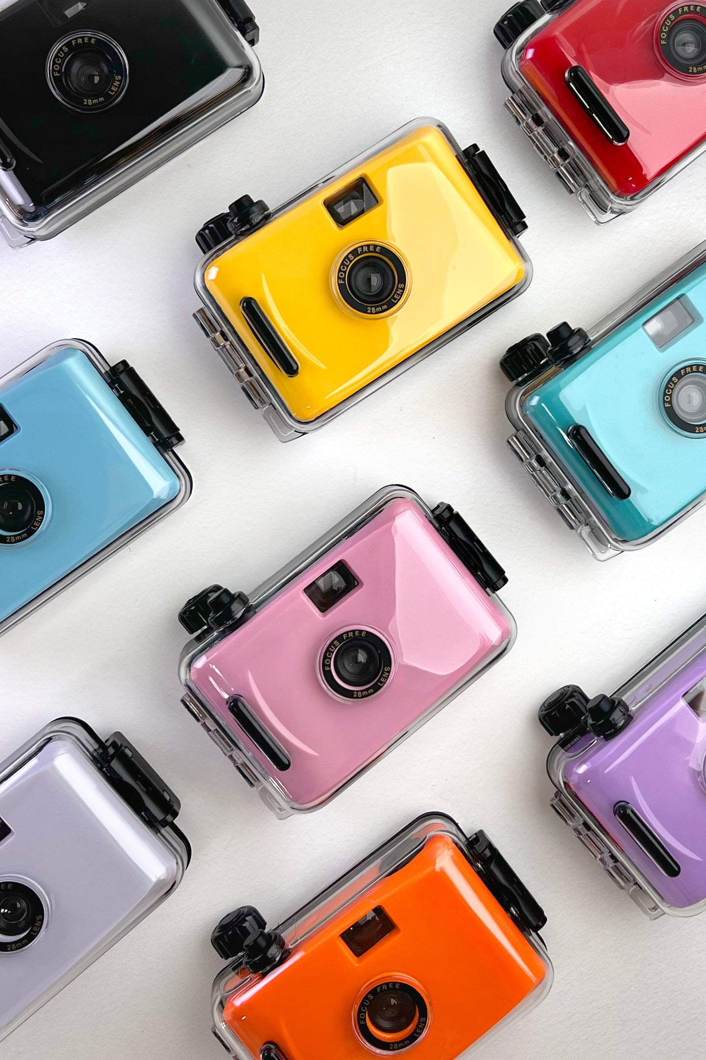 Colorful reusable film cameras arranged on a white background