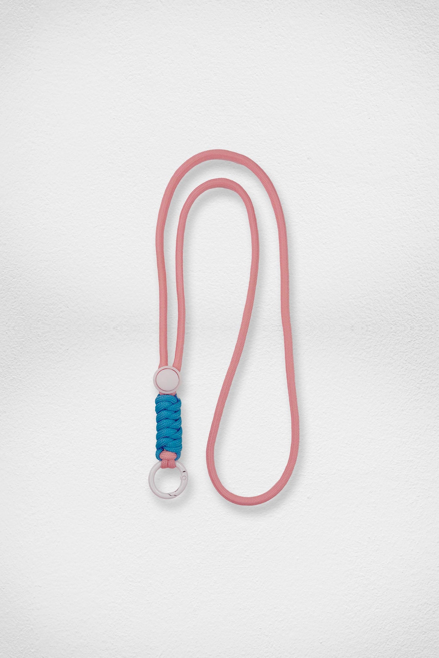 Pink and blue lanyard with a white metal ring on a white background