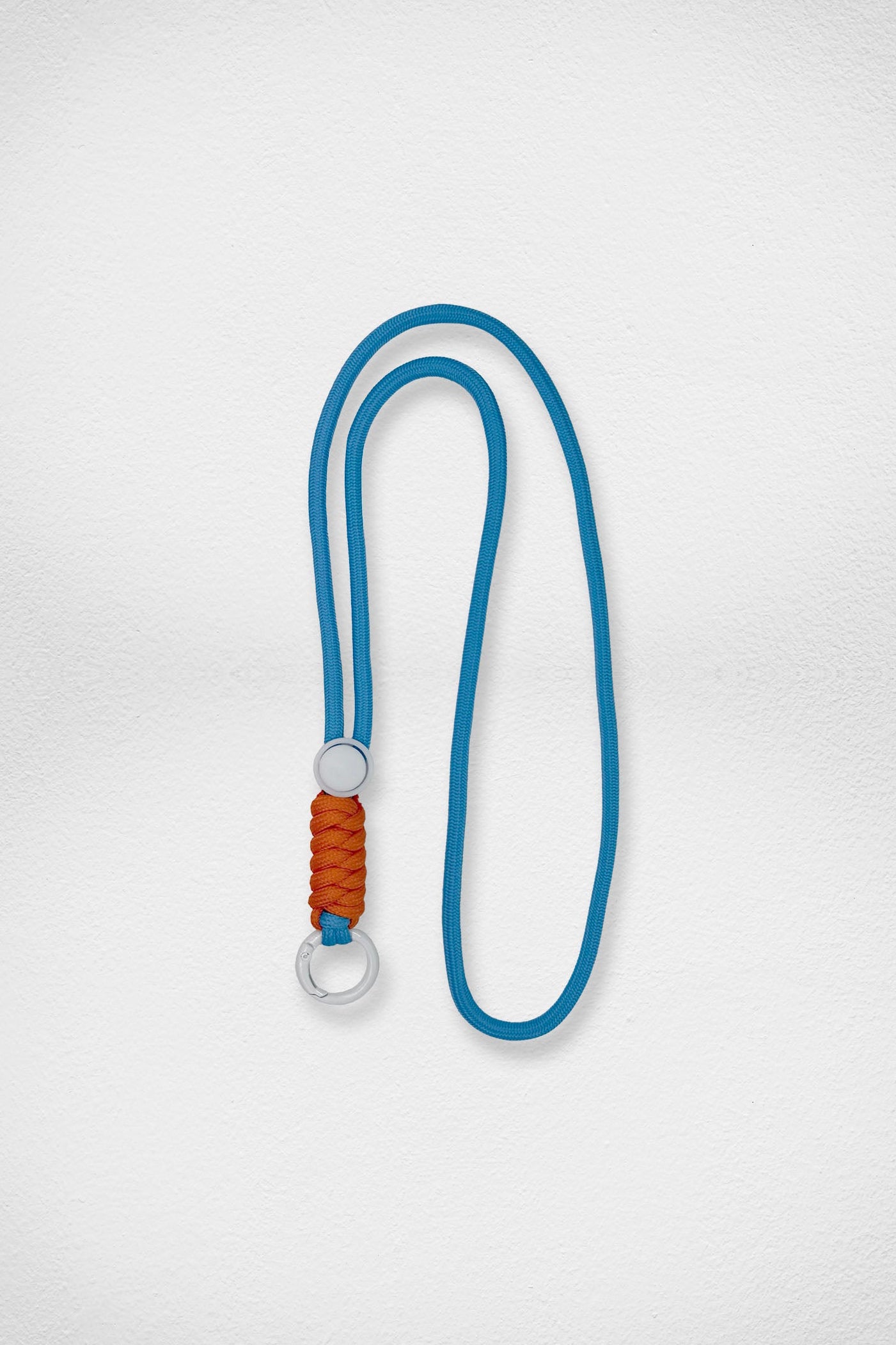 Blue lanyard with a brown accent and white metal ring on a light gray background